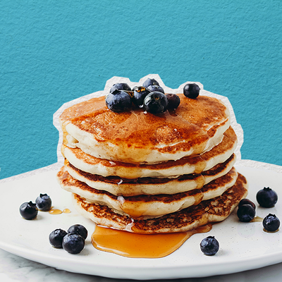 An image of a stack of vegan pancakes and blueberries